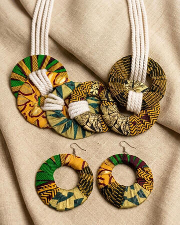 Afrokubanisches Ankara Ketten und Ohrringe Set mit Seildetails. Geflochtenes Seil trifft auf lebendigen Ankara Wachsdruck. Dieses Set verbindet Struktur und Farbe zu einem ausdrucksstarken Schmuckstück. Entdecken Sie die Vielfalt der Kollektion und fin