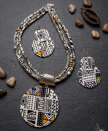 Afrokubanisches Bogolan Schmuckset mit Kreisanhänger und Ohrringen. Inspiriert von traditionellen Mustern vereint dieses Set kulturelle Tiefe mit modernem Design und ausdrucksstarken Formen.