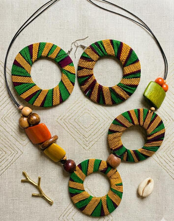 Afrokubanische Ankara Halskette mit Doppelkreis Anhänger und Holzperlen. Intensive Farben treffen auf natürliche Materialien und schaffen ein ausdrucksstarkes Design mit Charakter. Perfekt als Blickfang.