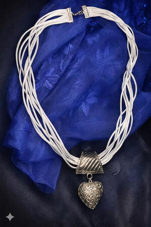 Weißes Mehrstrang Collier mit Herzanhänger. Elegante Linien und ein zentrales Detail machen dieses Collier zu einem stilvollen Begleiter.